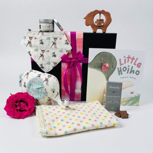 The Sweet Baby Girl Gift Basket. Filled with NZ made products including a handmade elephant soft toy, a bib, wrap, sheep rattle, little hoiho book, scented candle and a bar of Bennetts of Mangawhai chocolate. Baby gifts NZ. Gifts for You & Me