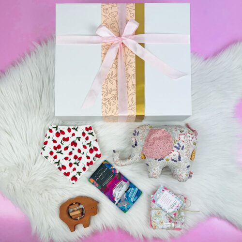 The Precious Baby Girl Gift Hamper is the perfect gift box for babies. Contained in the luxury gift box is a handmade one of a kind elephant soft toy, a handmade bib and wash cloths, sheep rattle and a bar of Wellington Chocolate Factory chocolate. Gift Boxes NZ. Gifts for You & Me.